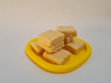 Sarı bir kabın içinde gofret adı verilen gevrek ve tatlı şekerden yapılmış atıştırmalıklar.