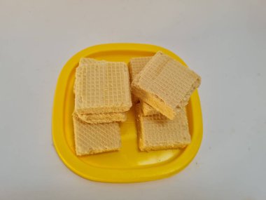 Sarı bir kabın içinde gofret adı verilen gevrek ve tatlı şekerden yapılmış atıştırmalıklar.