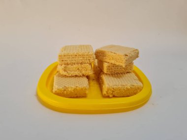 Sarı bir kabın içinde gofret adı verilen gevrek ve tatlı şekerden yapılmış atıştırmalıklar.