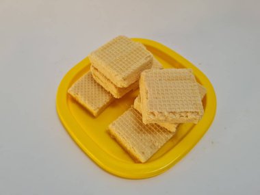 Sarı bir kabın içinde gofret adı verilen gevrek ve tatlı şekerden yapılmış atıştırmalıklar.