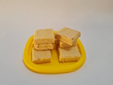 Sarı bir kabın içinde gofret adı verilen gevrek ve tatlı şekerden yapılmış atıştırmalıklar.