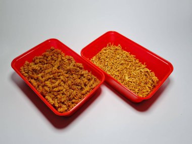 Baharatlı makarna ve beyaz ve gri kombinasyonda izole edilmiş baharatlı çıtır erişte.