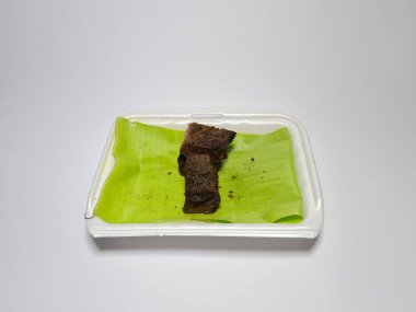 Beyaz kabın içinde yeşil sebzeli kızarmış et dilimleri.