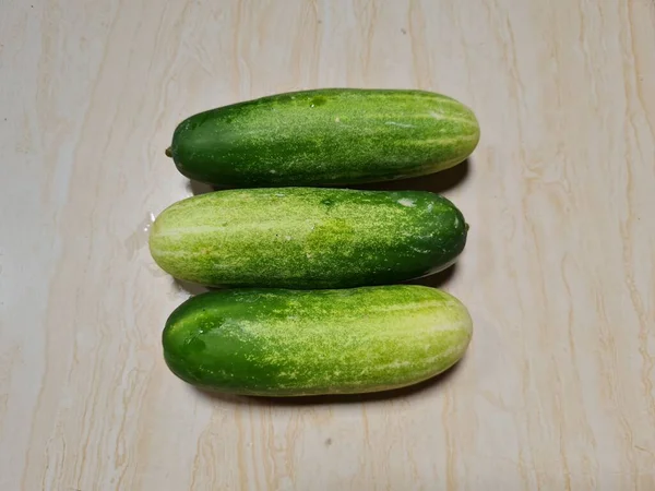 Drei Grüne Gurken Kombiniert Mit Weißen Fasern Auf Weißbraunem Porzellanboden — Stockfoto