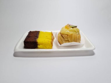 Beyaz bir kabın içinde Endonezya atıştırmalıkları, sandviçler ve meyve suyu.