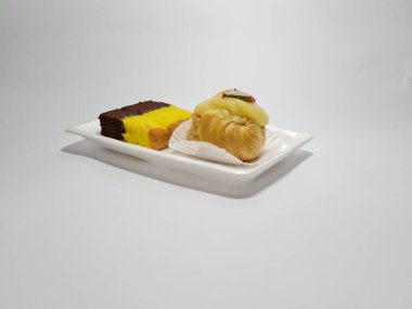 Beyaz bir kabın içinde Endonezya atıştırmalıkları, sandviçler ve meyve suyu.