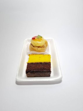 Beyaz bir kabın içinde Endonezya atıştırmalıkları, sandviçler ve meyve suyu.