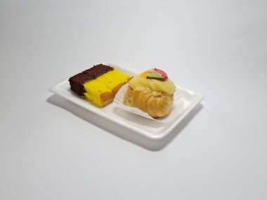 Beyaz bir kabın içinde Endonezya atıştırmalıkları, sandviçler ve meyve suyu.