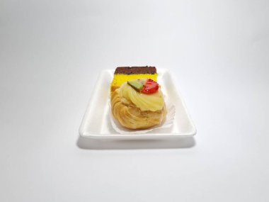 Beyaz bir kabın içinde Endonezya atıştırmalıkları, sandviçler ve meyve suyu.