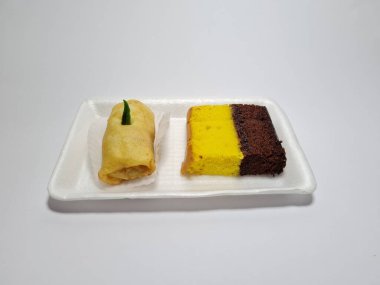 Beyaz bir kapta tipik Endonezya atıştırmalıkları, sandviçler ve börekler.