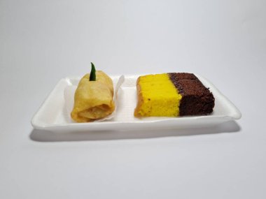 Beyaz bir kapta tipik Endonezya atıştırmalıkları, sandviçler ve börekler.