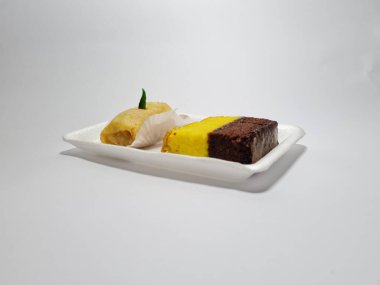 Beyaz bir kapta tipik Endonezya atıştırmalıkları, sandviçler ve börekler.