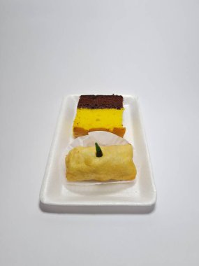 Beyaz bir kapta tipik Endonezya atıştırmalıkları, sandviçler ve börekler.