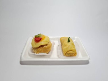 Beyaz bir kabın içinde tipik Endonezya atıştırmalıkları, meyveli ekler ve börekler.