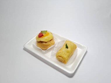 Beyaz bir kabın içinde tipik Endonezya atıştırmalıkları, meyveli ekler ve börekler.