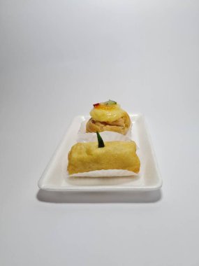 Beyaz bir kabın içinde tipik Endonezya atıştırmalıkları, meyveli ekler ve börekler.