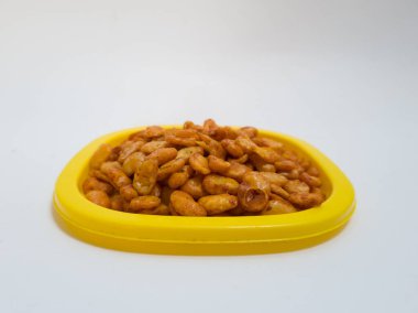 Fıstık koro adında bir atıştırmalık, kızarmış ve sarı bir kabın içinde tatlı ve baharatlı kırmızı baharat verilmiş.