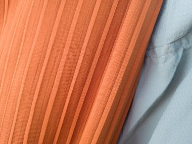 Soyut kumaş desenli turuncu arka plan ve açık mavi karışımı.