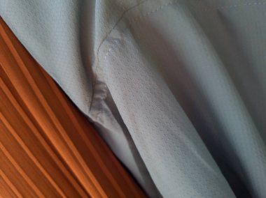 Soyut kumaş desenli turuncu arka plan ve açık mavi karışımı.