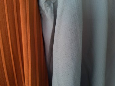 Soyut kumaş desenli turuncu arka plan ve açık mavi karışımı.