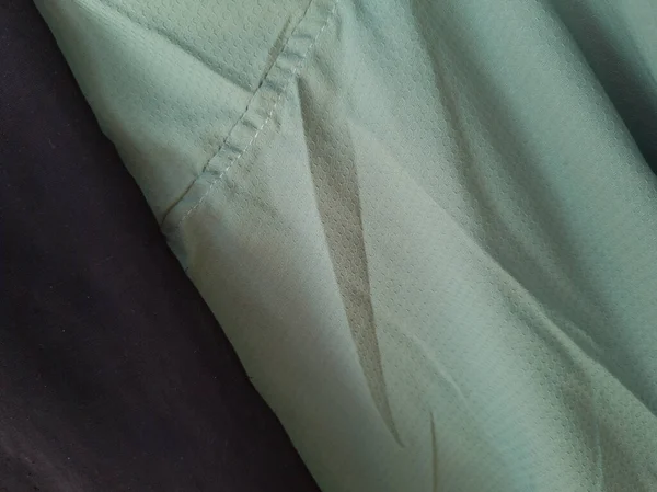 Soyut arkaplan desenli açık yeşil kumaş bir gölge oluşturmak için katlanır