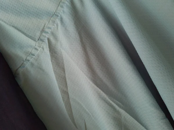 Soyut arkaplan desenli açık yeşil kumaş bir gölge oluşturmak için katlanır