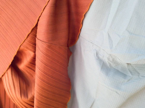 Soyut kumaş desenli turuncu arka plan ve açık mavi karışımı.