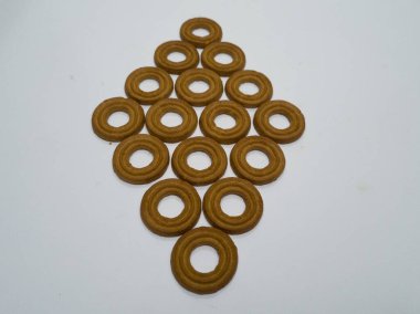 Yuvarlak bir tereyağlı pasta ve beyaz arka planda çok sayıda çikolata aromalı bir delik.