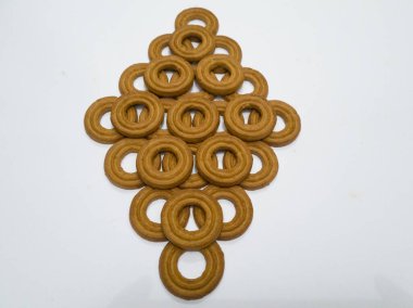 Yuvarlak bir tereyağlı pasta ve beyaz arka planda çok sayıda çikolata aromalı bir delik.