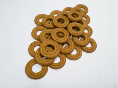 Yuvarlak bir tereyağlı pasta ve beyaz arka planda çok sayıda çikolata aromalı bir delik.