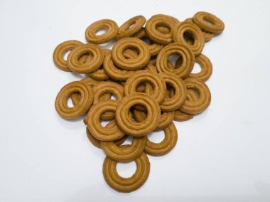 Yuvarlak bir tereyağlı pasta ve beyaz arka planda çok sayıda çikolata aromalı bir delik.