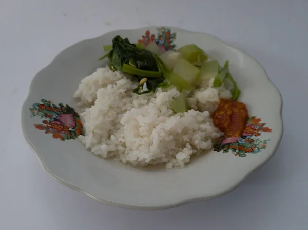 透明野菜の白飯とトマトソースで構成されたホワイトプレートで提供されるインドネシア料理 — ストック写真