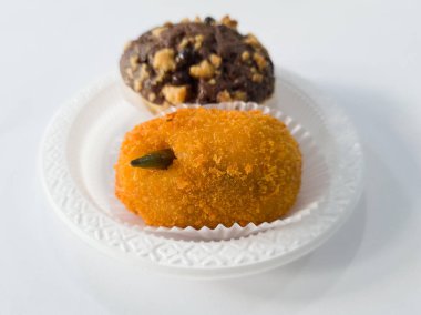 Un ve diğer malzemelerden yapılmış iki kek, yani çikolatalı kek ve patates kroketi.