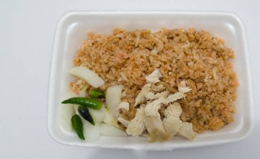 Kızarmış tavuk dilimleri, salatalık dilimleri ve yeşil biberli kızarmış pirinç.