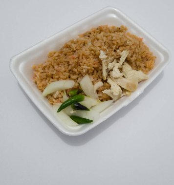 Kızarmış tavuk dilimleri, salatalık dilimleri ve yeşil biberli kızarmış pirinç.