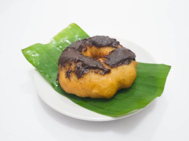 Yeşil muz yaprağının üzerinde un ve diğer malzemelerden yapılmış çikolatalı çörek.