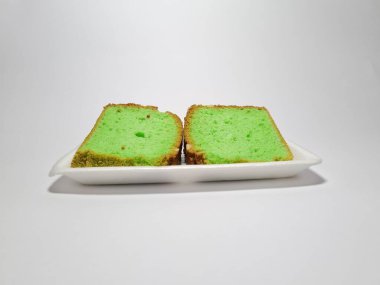 Beyaz kabın içinde yeşil pandan aromalı pandispanya keki.