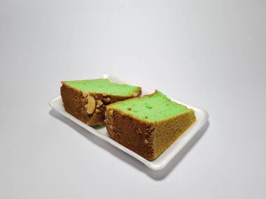 Beyaz kabın içinde yeşil pandan aromalı pandispanya keki.