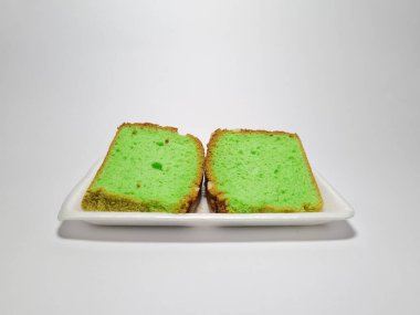 Beyaz kabın içinde yeşil pandan aromalı pandispanya keki.
