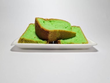 Beyaz kabın içinde yeşil pandan aromalı pandispanya keki.