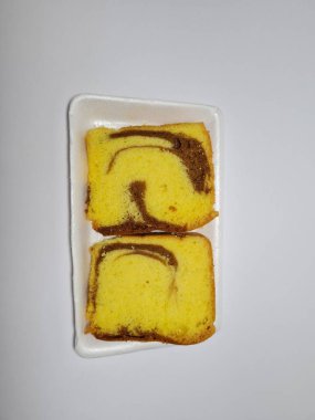 Beyaz kabın içinde yeşil pandan aromalı pandispanya keki.