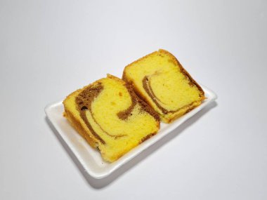 Beyaz kabın içinde yeşil pandan aromalı pandispanya keki.