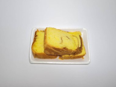 Beyaz kabın içinde yeşil pandan aromalı pandispanya keki.