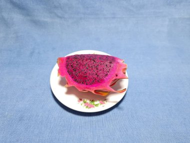 Mavi arka planda kırmızı ejderha meyvesi dilimleri