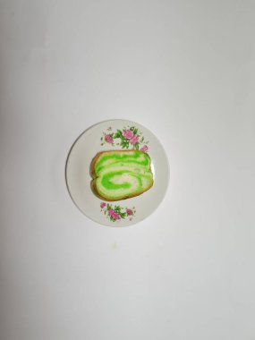 Beyaz tabakta yeşil pandan aromalı ekmek.