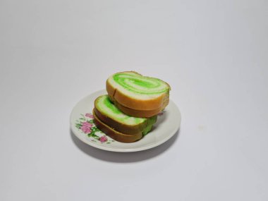 Beyaz tabakta yeşil pandan aromalı ekmek.