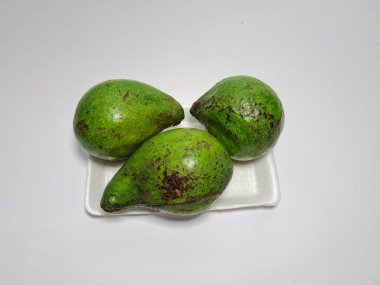 Beyaz bir kabın içinde yeşil avokado fotoğrafı.