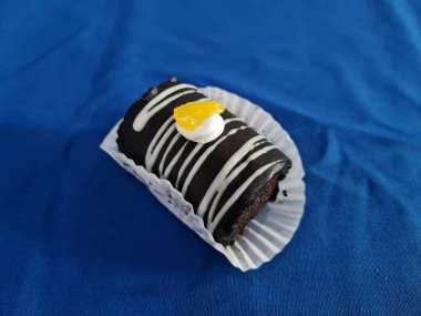 Çikolata ruloları reçel ve beyaz kremayla dolu mavi arka planda