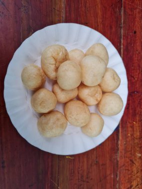 Yuvarlak kahverengi levrek krakerleri tahta bir masada beyaz bir konteynırda