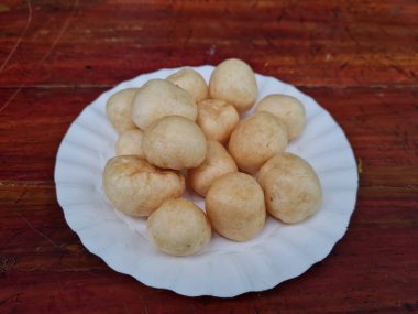 Yuvarlak kahverengi levrek krakerleri tahta bir masada beyaz bir konteynırda